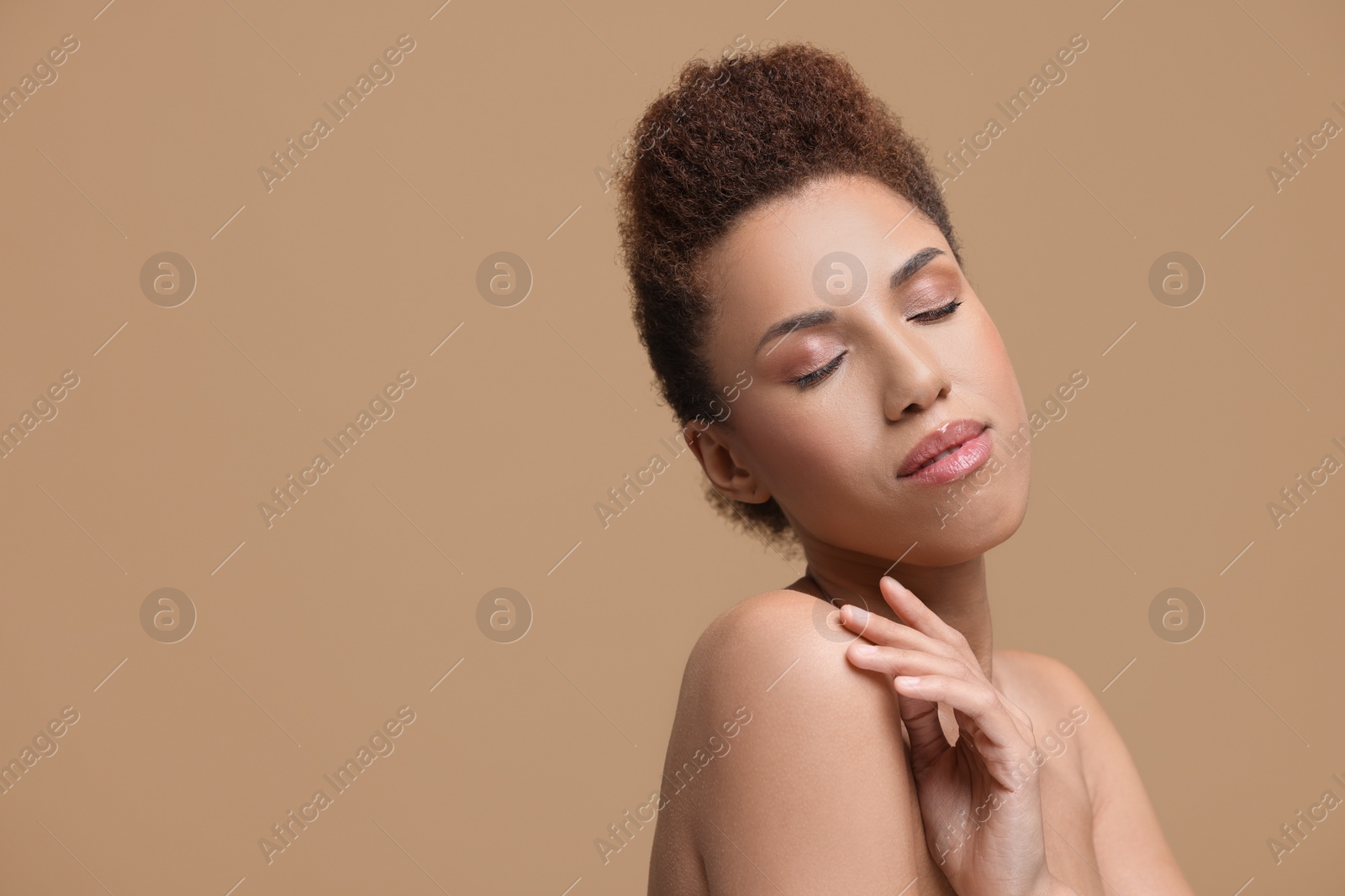 Photo of Portrait of beautiful young woman with glamorous makeup on light brown background. Space for text