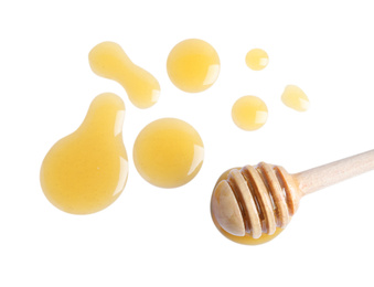 Photo of Drops of honey and dipper on white background, top view