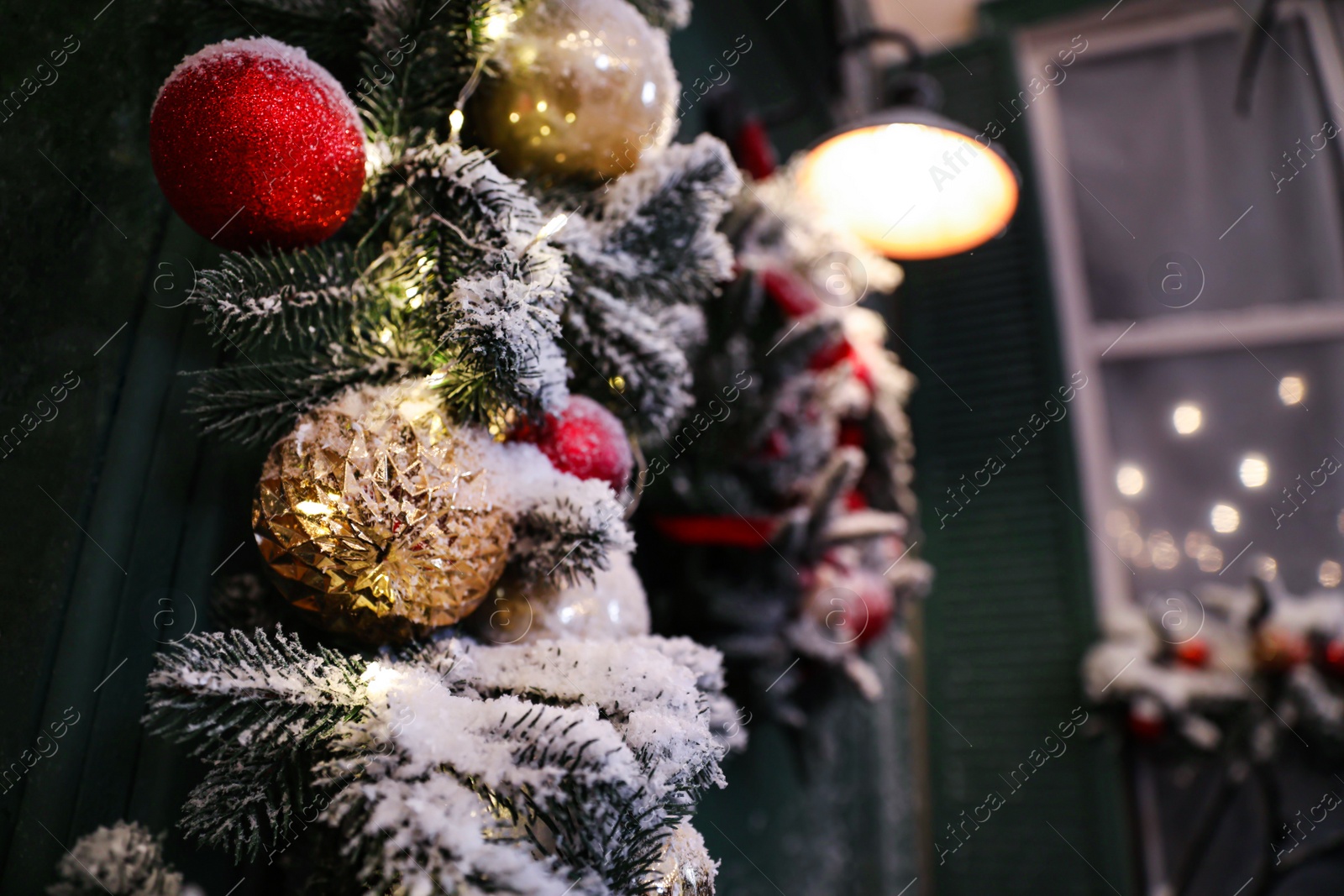Photo of Beautiful decorative garland covered with snow outdoors, closeup. Christmas celebration