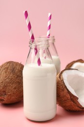 Delicious vegan milk and coconuts on pink background