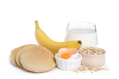 Tasty oatmeal pancakes and ingredients on white background