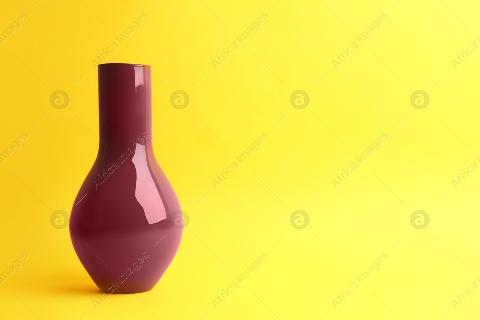 Photo of Stylish empty ceramic vase on yellow background, space for text