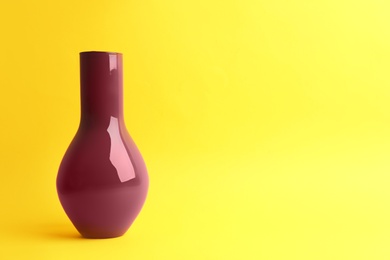 Stylish empty ceramic vase on yellow background, space for text