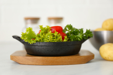 Portioned frying pan with products on table