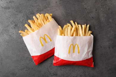Photo of MYKOLAIV, UKRAINE - AUGUST 12, 2021: Two small portions of McDonald's French fries on grey table, flat lay