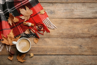 Photo of Flat lay composition with coffee and warm plaid on wooden table, space for text