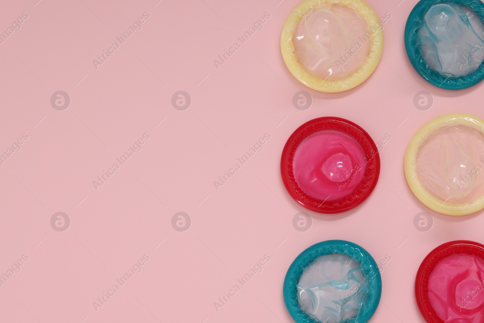 Photo of Condoms on pink background, flat lay with space for text. Safe sex
