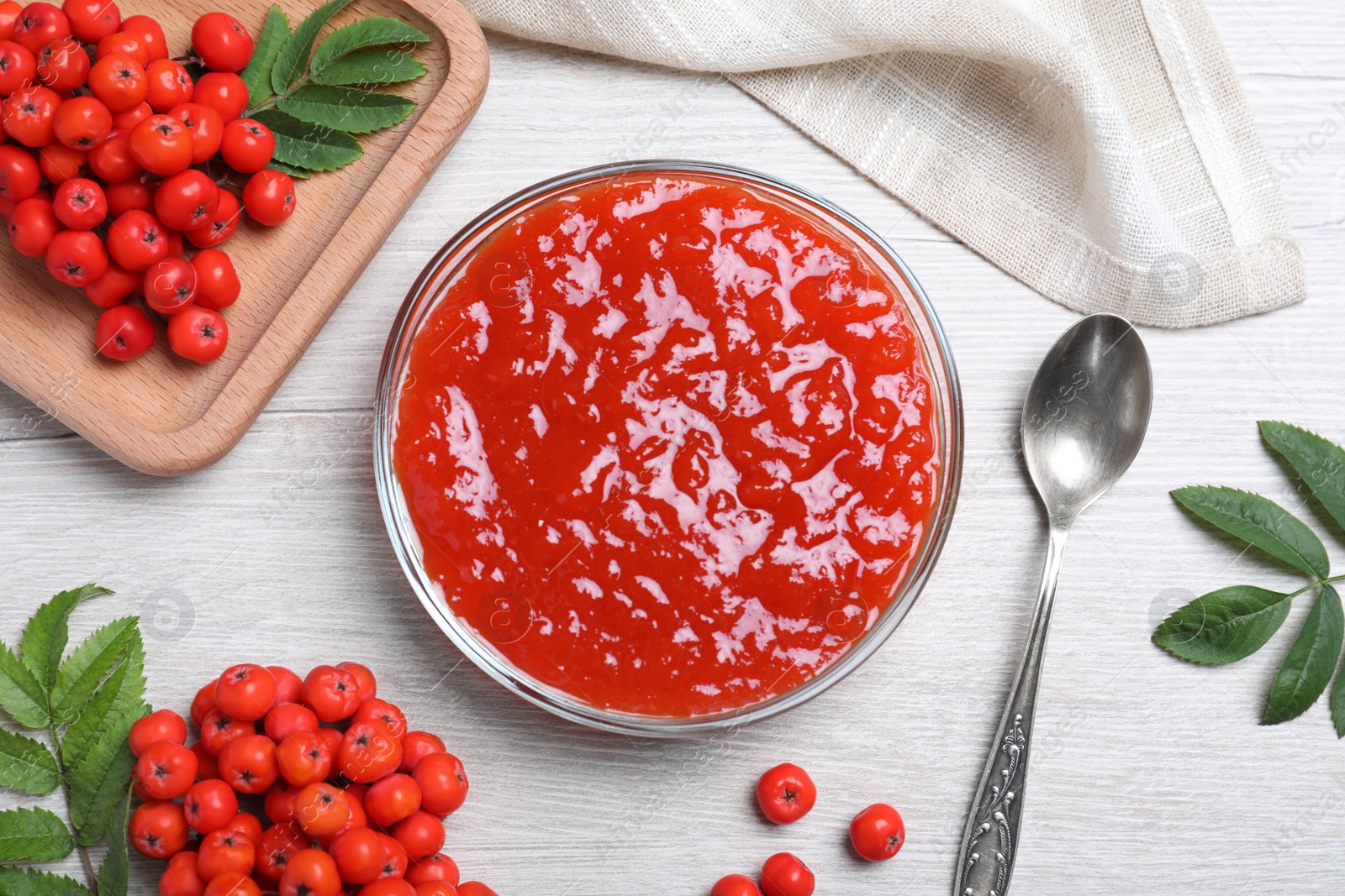 Photo of Flat lay composition with delicious rowan jam on white wooden table