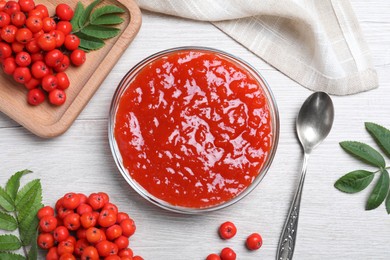 Flat lay composition with delicious rowan jam on white wooden table