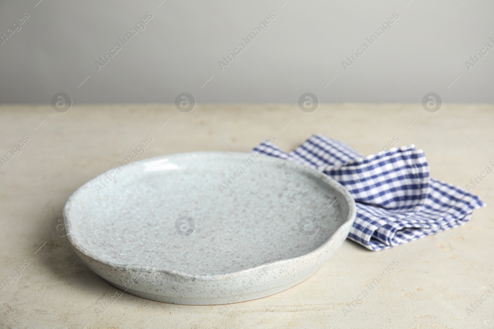 Photo of Empty plate and napkin on light table