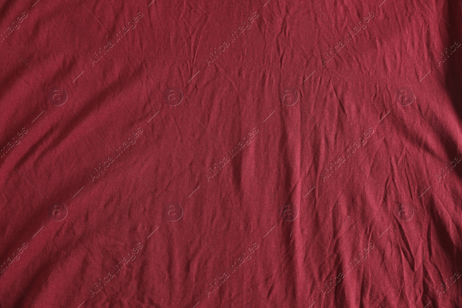 Photo of Crumpled dark red fabric as background, top view