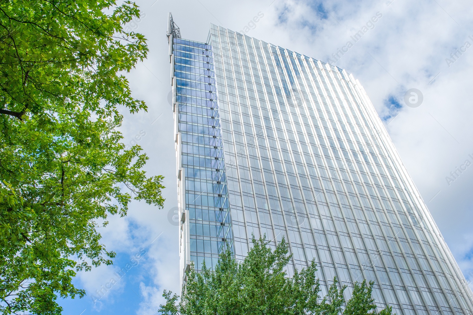 Photo of Beautiful skyscraper with many windows on cloudy day, low angle view