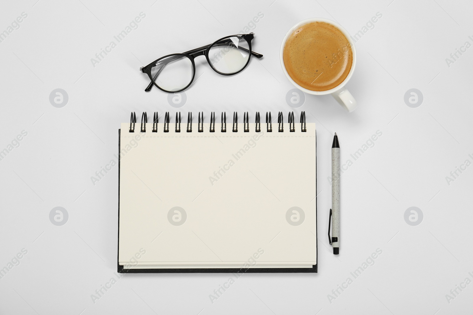 Photo of Open notebook, coffee, pen and glasses on table, flat lay