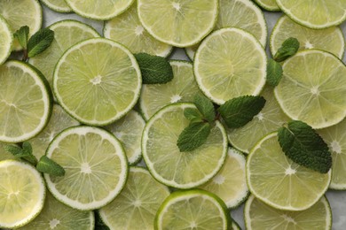 Photo of Slices of fresh juicy limes as background, top view
