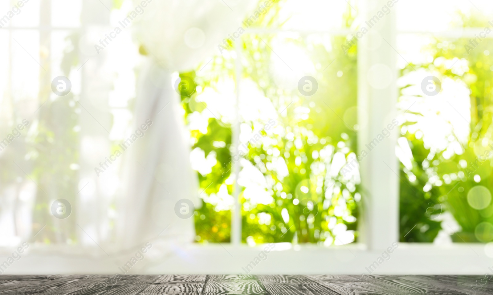 Image of Wooden table and view through window on garden in morning. Springtime