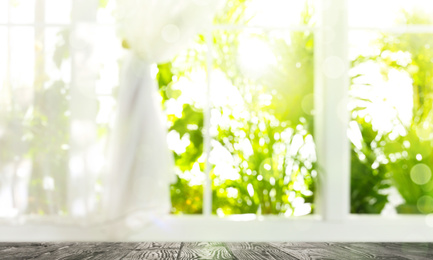 Image of Wooden table and view through window on garden in morning. Springtime