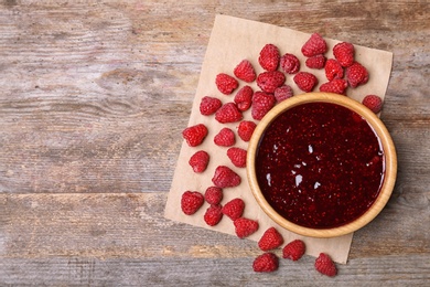 Flat lay composition with delicious raspberry jam on wooden background