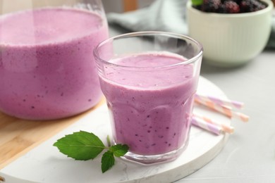 Photo of Delicious blackberry smoothie and mint on white table, closeup