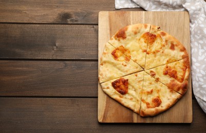 Delicious khachapuri with cheese on wooden table, top view. Space for text