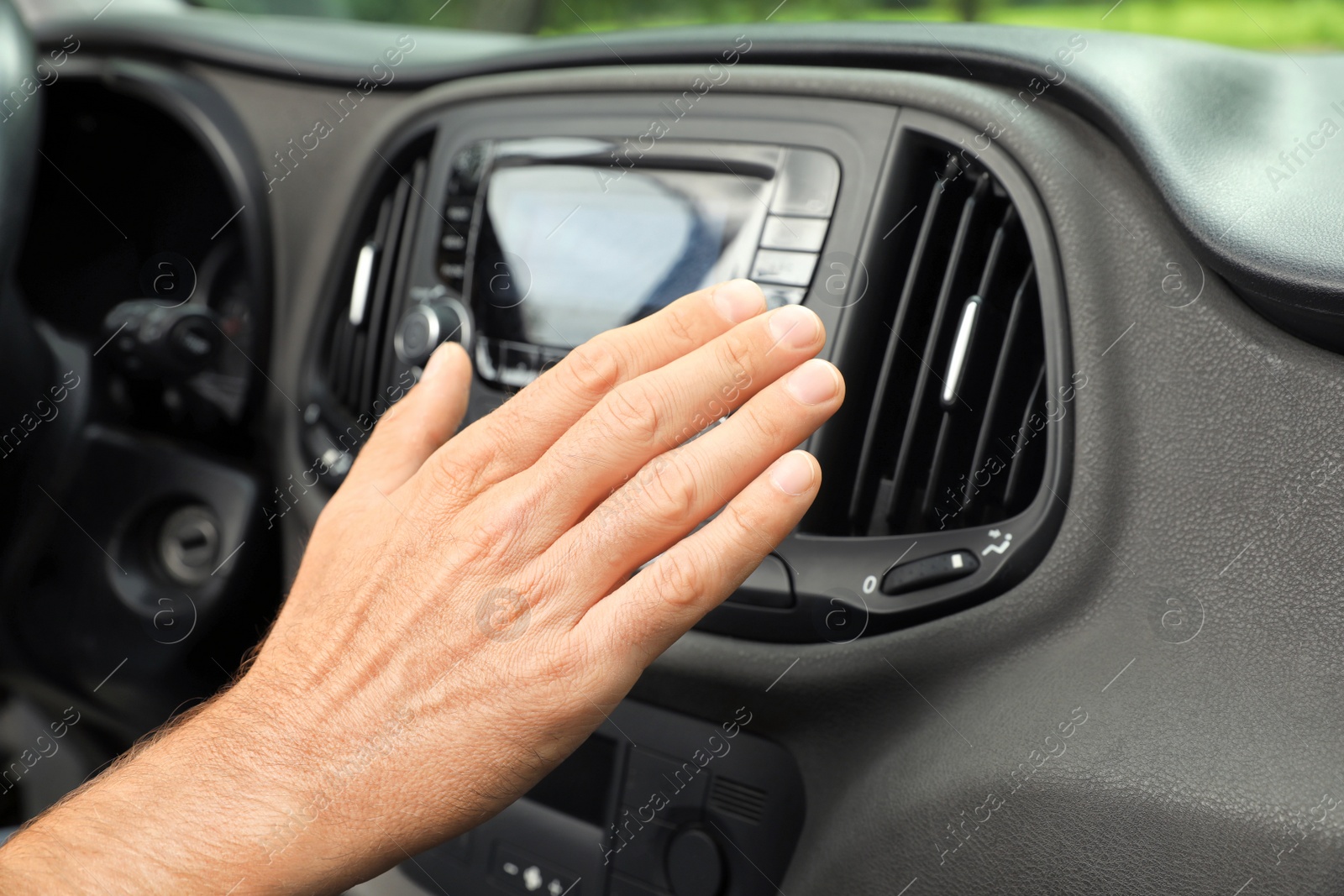 Photo of Man checking work of air conditioner in car, closeup