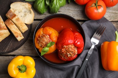 Delicious stuffed peppers served on wooden table, flat lay