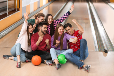Group of friends taking selfie in bowling club
