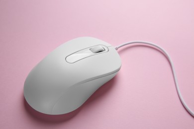 One wired mouse on pink background, closeup