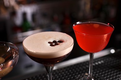 Photo of Glasses of different Martini cocktails on bar counter, closeup