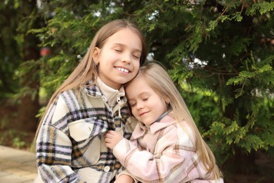 Cute little sisters spending time together outdoors