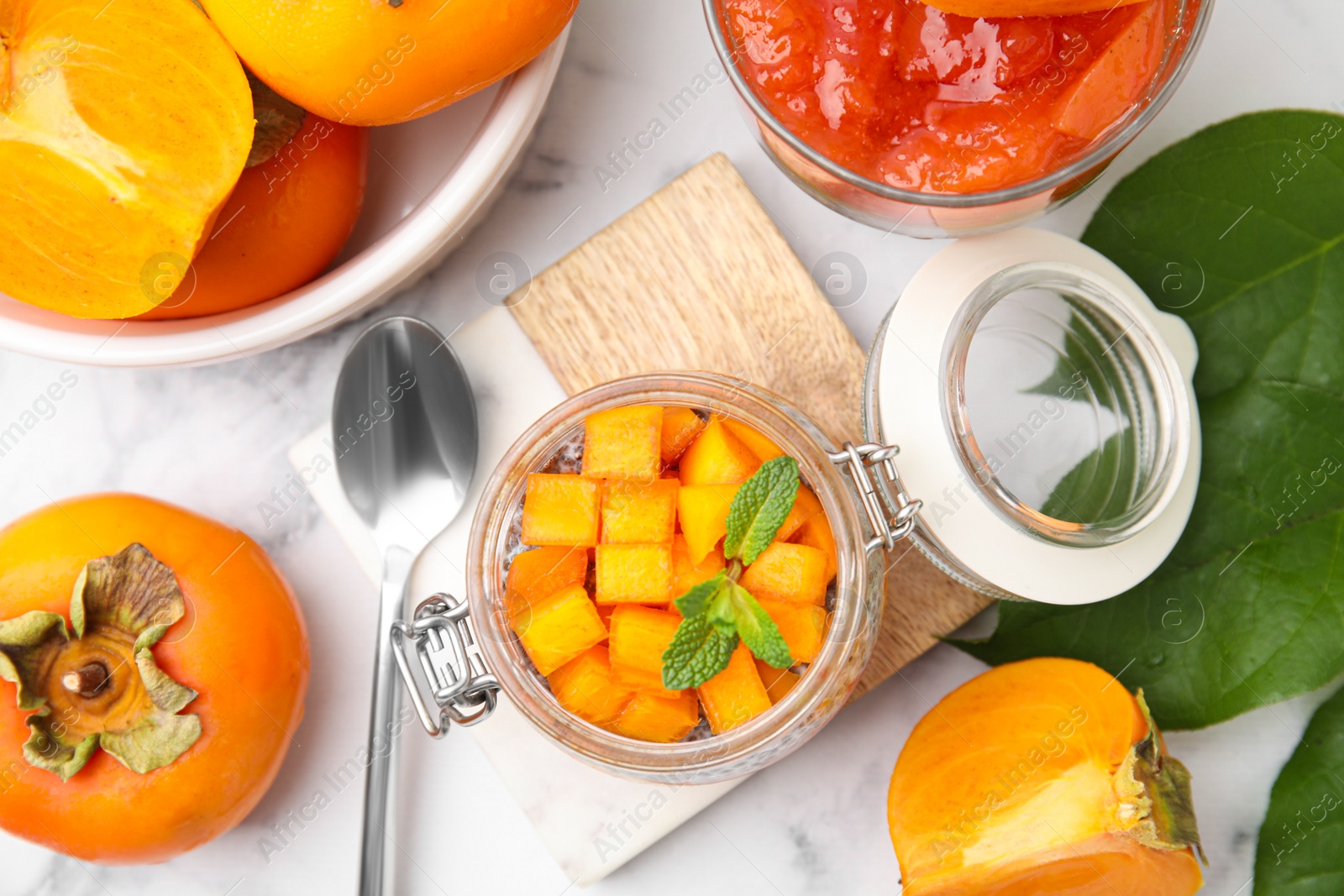 Photo of Delicious dessert with persimmon on table, flat lay