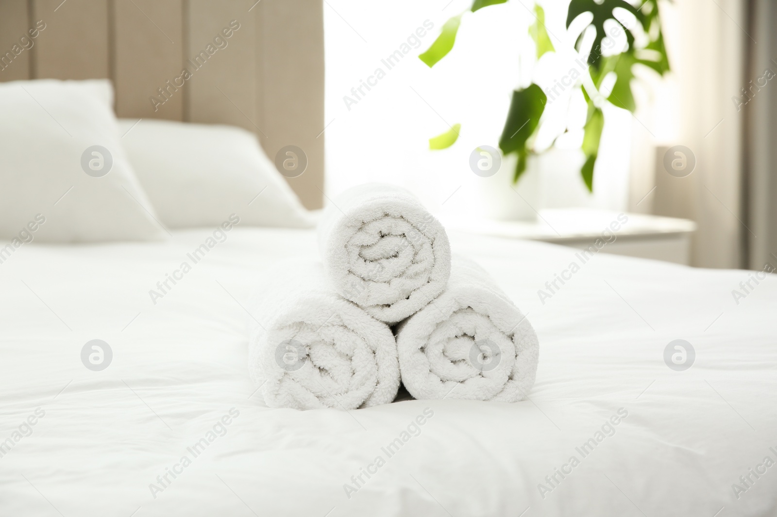 Photo of Clean white towels on bed at home
