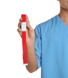 Photo of Male doctor holding tourniquet on white background, closeup. Medical object