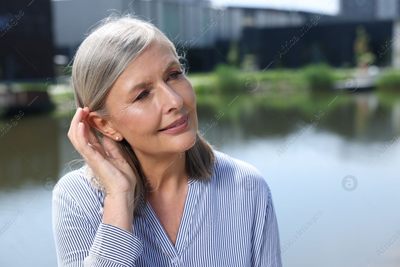 Photo of Portrait of beautiful smiling senior woman outdoors, space for text