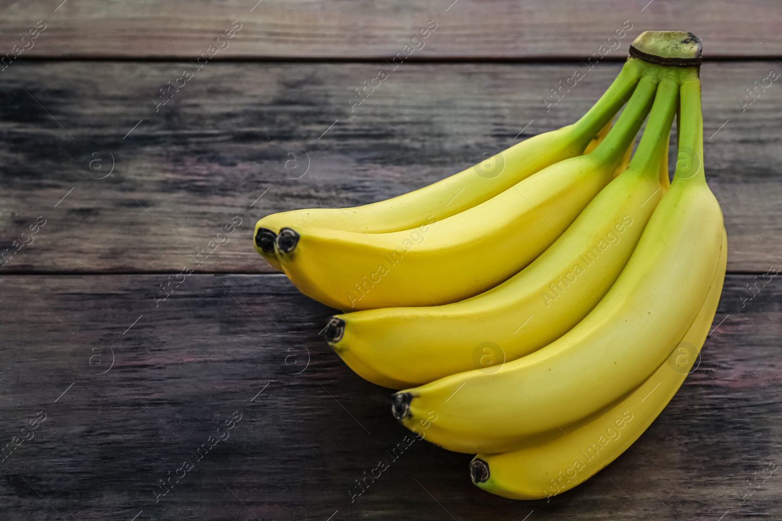 Photo of Bunch of ripe yellow bananas on wooden table