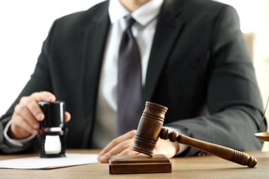 Gavel and blurred view of notary on background