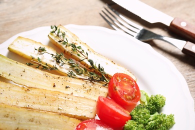 Photo of Baked white carrot with vegetables on plate, closeup