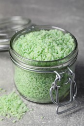 Photo of Jar with green sea salt on light grey table, closeup