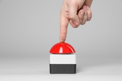 Photo of Man pressing red button of nuclear weapon on light gray background, closeup. War concept