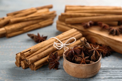 Aromatic cinnamon sticks and anise on grey wooden table, closeup