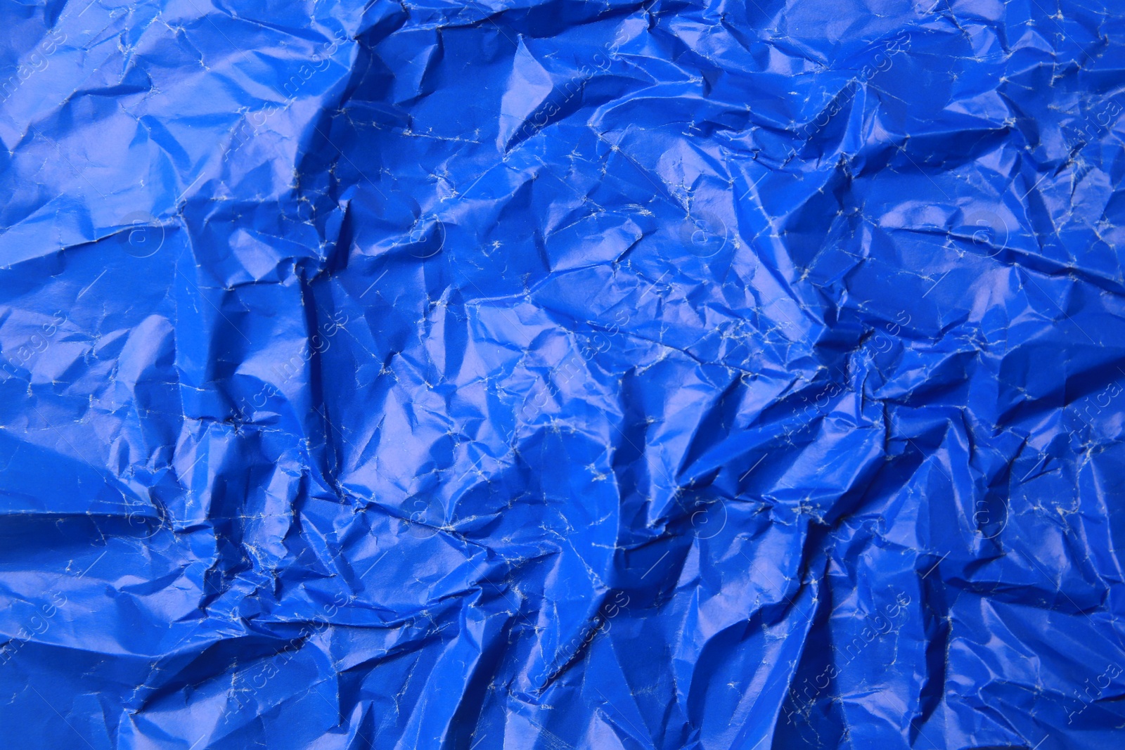 Photo of Sheet of crumpled blue paper as background, top view