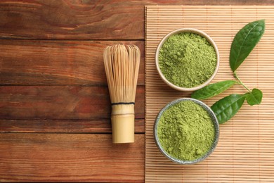 Green matcha powder and bamboo whisk on wooden table, flat lay. Space for text