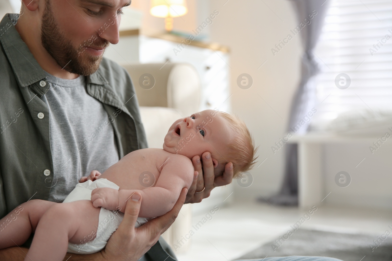 Photo of Father with his newborn son at home