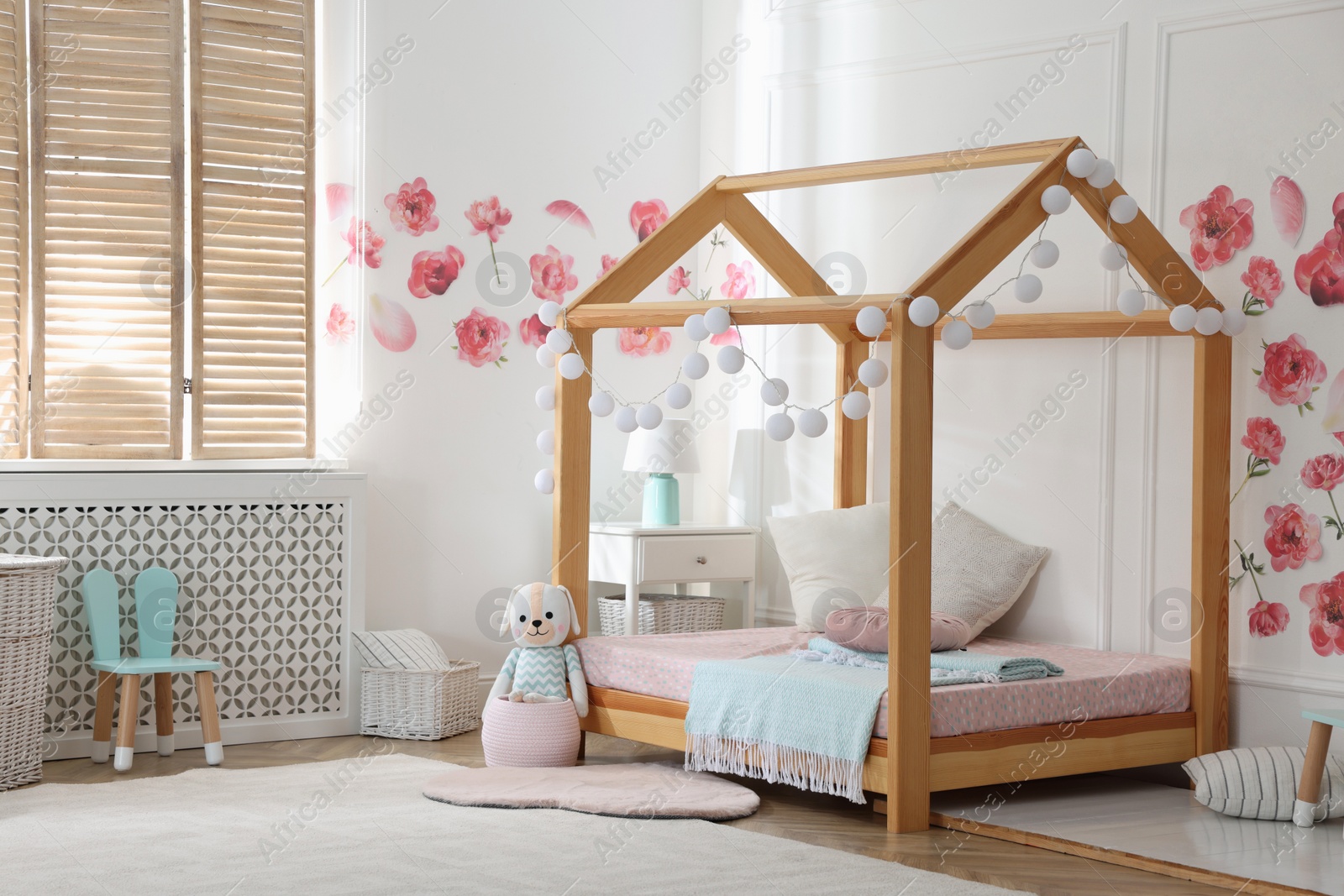 Photo of Stylish child room interior with wooden house bed