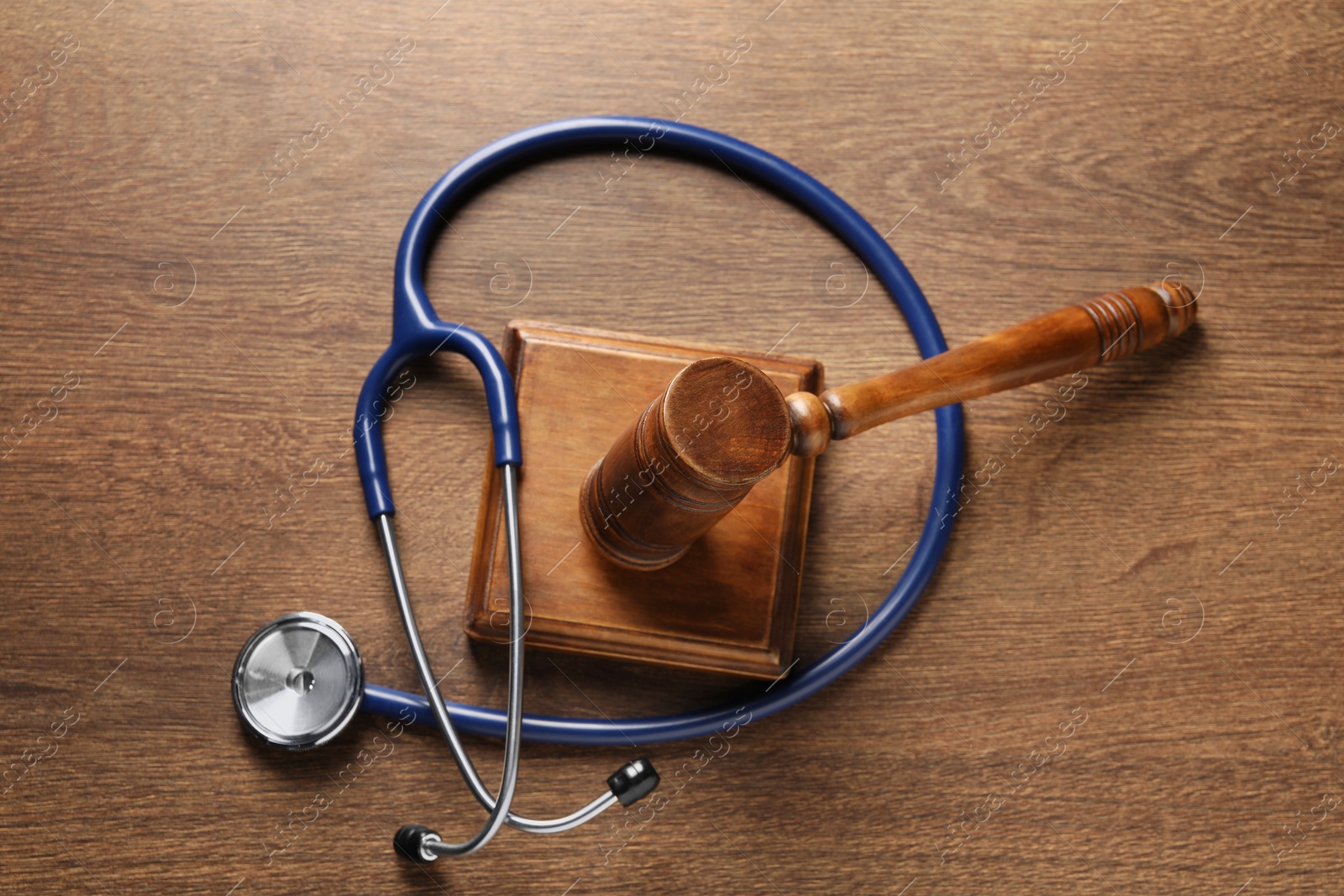 Photo of Law concept. Gavel and stethoscope on wooden table, top view
