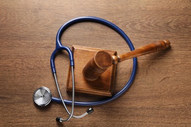 Law concept. Gavel and stethoscope on wooden table, top view