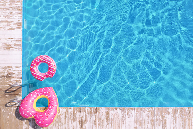 Image of Swimming pool with inflatable rings, top view. Space for text