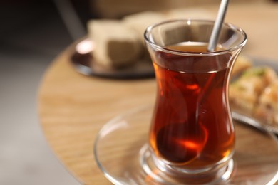 Photo of Traditional Turkish tea in glass on table, closeup. Space for text