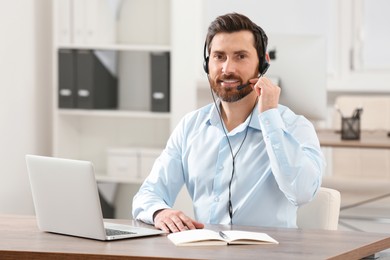 Hotline operator with headset working in office