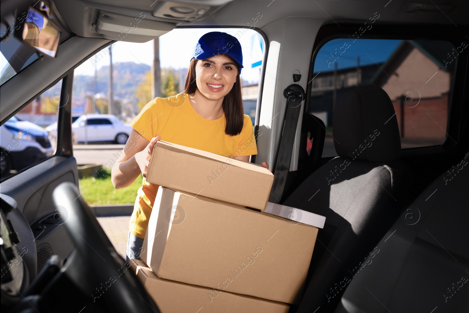 Photo of Courier taking parcel from car. Delivery service