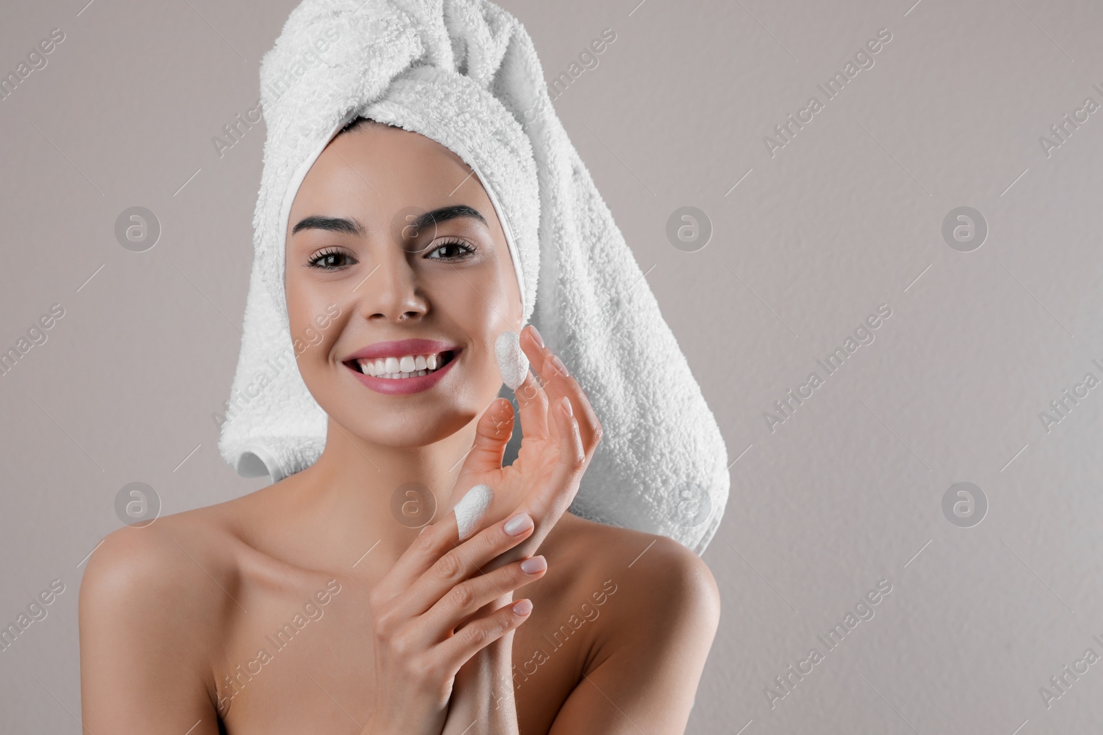 Photo of Woman using silkworm cocoons in skin care routine on light grey background. Space for text